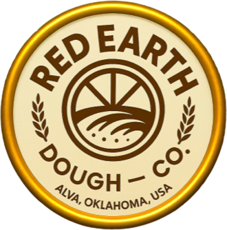 Circular logo with the text "Red Earth Dough Co." and "Alva, Oklahoma, USA" surrounding a stylized image of a sun over fields, flanked by wheat stalks.